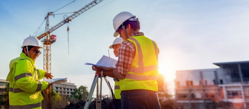 Construction engineers discussion with architects at construction site or building site of highrise building with Surveying for making contour plans is a graphical representation of the lay in land.