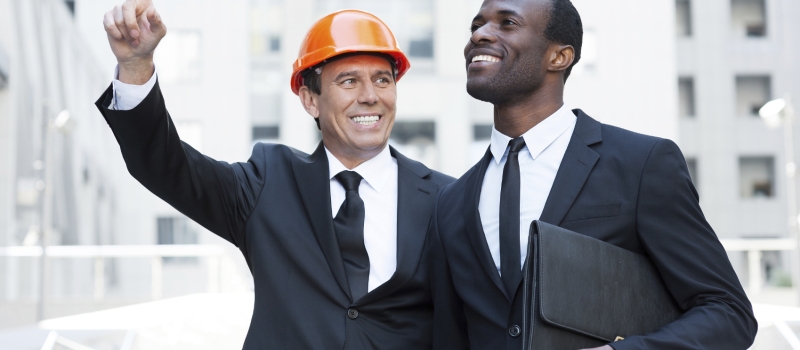 Showing opportunities. Cheerful contractor in hardhat pointing a